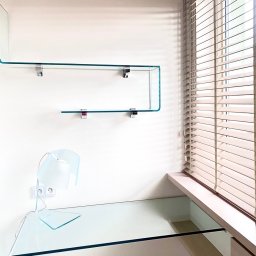 Szklane biurko Fiam Italia, szklane półki oraz lampka biurkowa również pochodzą z kolekcji włoskiej firmy Fiam Italia. Realizacja domowego pokoju do pracy w wykonaniu architekt wnętrz ze Szczecina, Anny Buczny.