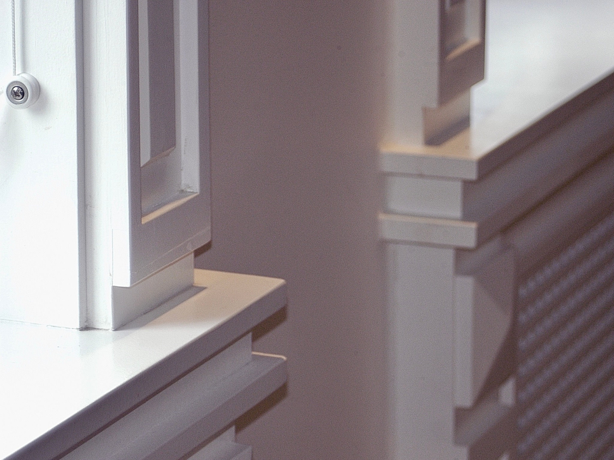 Detal architektoniczny: białe, kanciaste elementy dekoracyjne z włącznikiem światła na ścianie, tworzące minimalistyczny, nowoczesny design wnętrza.