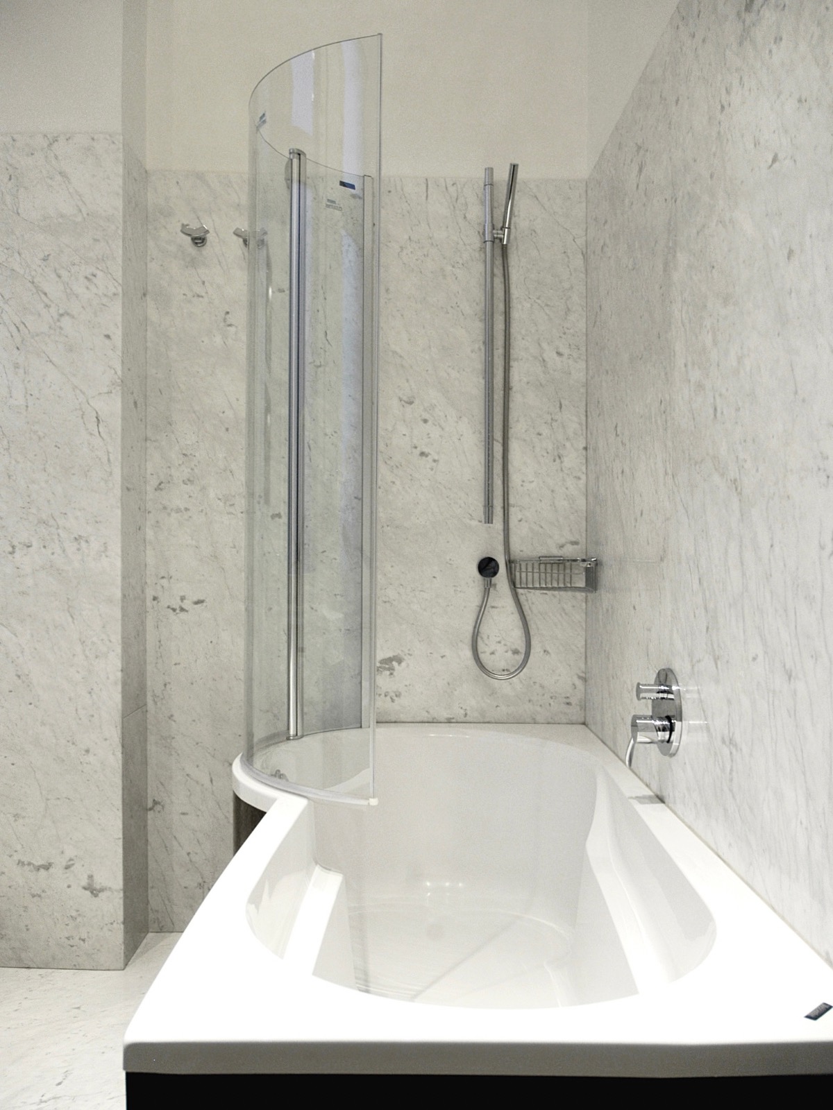 Wanna z parawanem nawannowym Dusholux w łazience wykończonej marmurem bianco carrara i drewnem wenge. Bateria wannowa na ścianie. Eklektyczna kamienica.