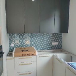 Kuchnia zabudowa kuchenna w dwóch kolorach. Fronty lakierowane półmat. Złote wygodne uchwyty. Górne szafki otwierane tip-on. 