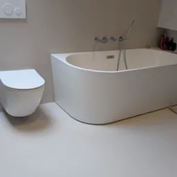 Biała, nowoczesna łazienka z podłogą i ścianami w jasnym odcieniu beżu. Widoczna wanna, toaleta podwieszana i armatura. Minimalistyczny design.