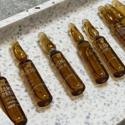 Skinlee - Salon Kosmetyczny Praga Południe Warszawa - Szklane ampułki z preparatami do peelingu chemicznego na marmurowej tacy. Widoczne napisy 'Xero Peel', 'Skin Step 2' i 'Redne Peel'.