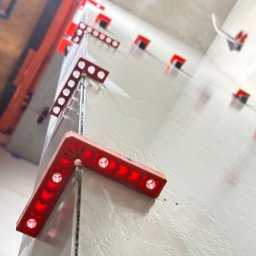 Świeżo położone płytki z systemem poziomowania w Sierakowicach. Widoczne czerwone klipsy i kliny. Ujęcie z niskiej perspektywy, podkreślające równość powierzchni.