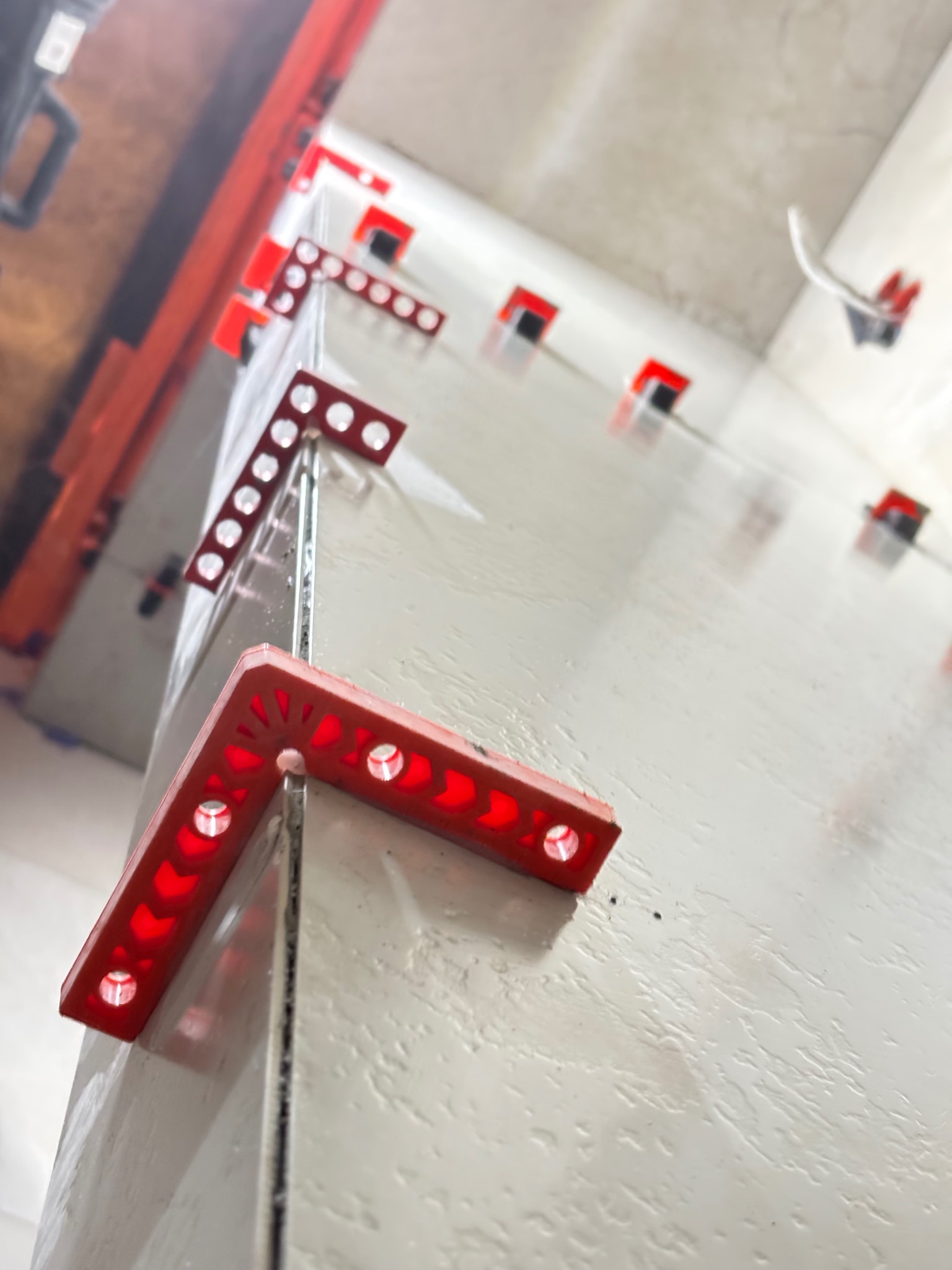 Świeżo położone płytki z systemem poziomowania w Sierakowicach. Widoczne czerwone klipsy i kliny. Ujęcie z niskiej perspektywy, podkreślające równość powierzchni.