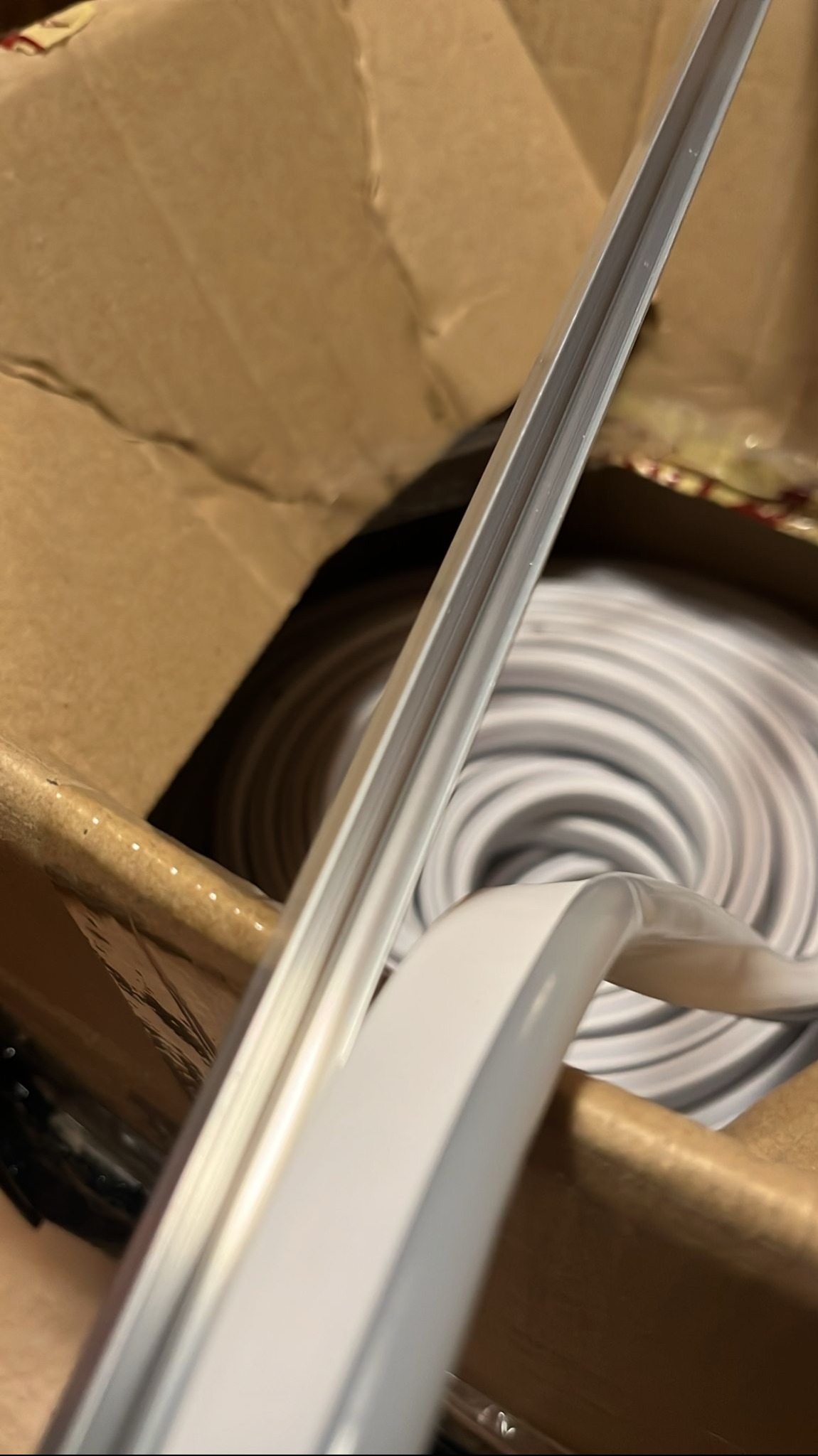 Kabel LED w kartonie, zwinięty w krąg. Widoczne detale profilu i struktury kabla. Ujęcie z bliska, podkreślające elastyczność i jakość materiału.