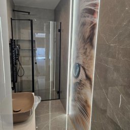 MBACZU MACIEJ CZUBA - Nowoczesna łazienka z kabiną prysznicową typu walk-in, umywalką nablatową i podświetlaną grafiką z kocim okiem na ścianie z płytek imitujących marmur.