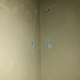 Szacht oddymiający po zabezpieczeniu ogniochronnym systemem Conlit 150. Widoczne włókno szklane i metalowe elementy mocujące.