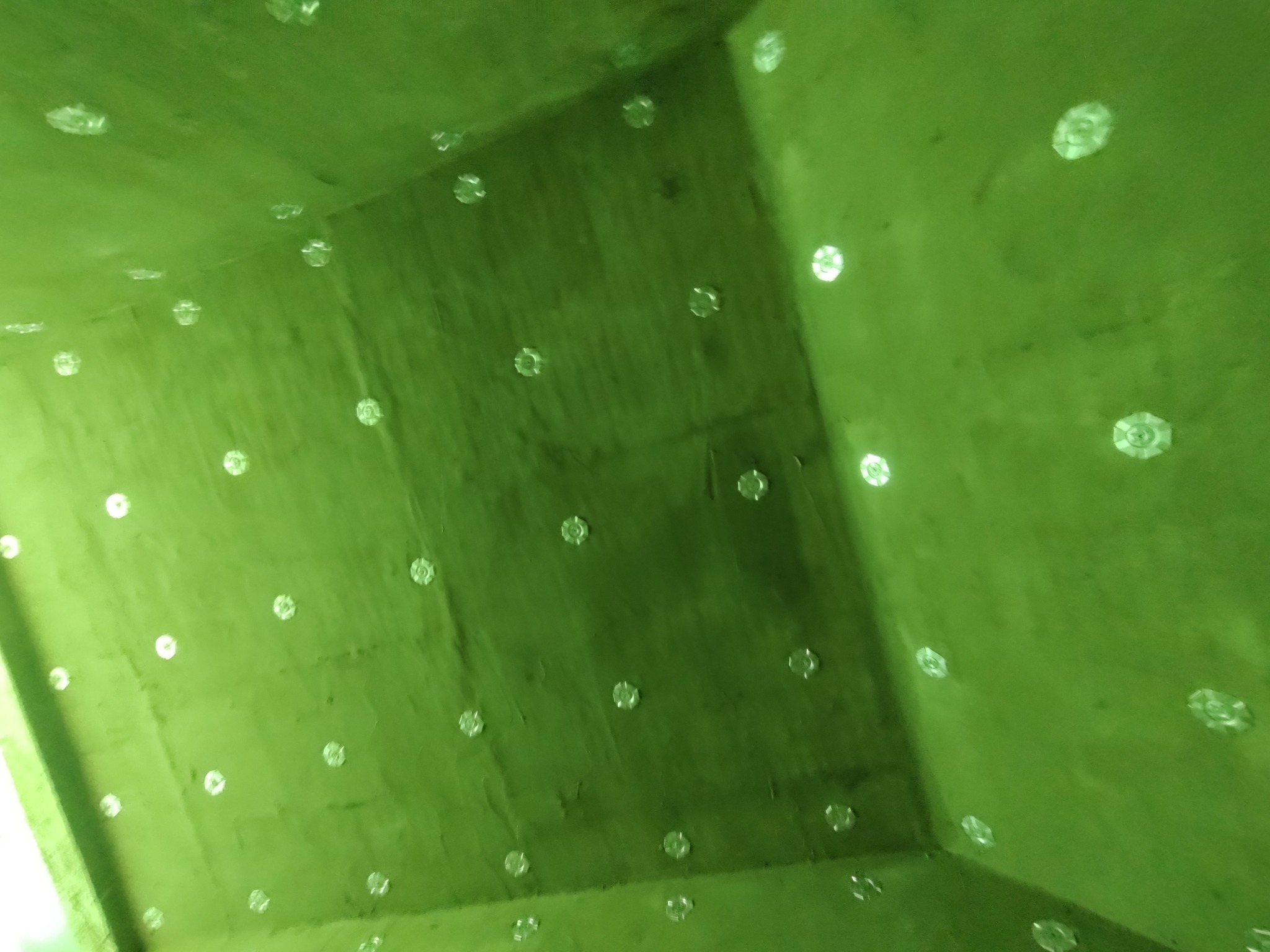 Szacht oddymiający po izolacji ogniochronnej i termicznej systemem CONLIT 150. Widoczne zielone ściany z przymocowanymi elementami mocującymi.