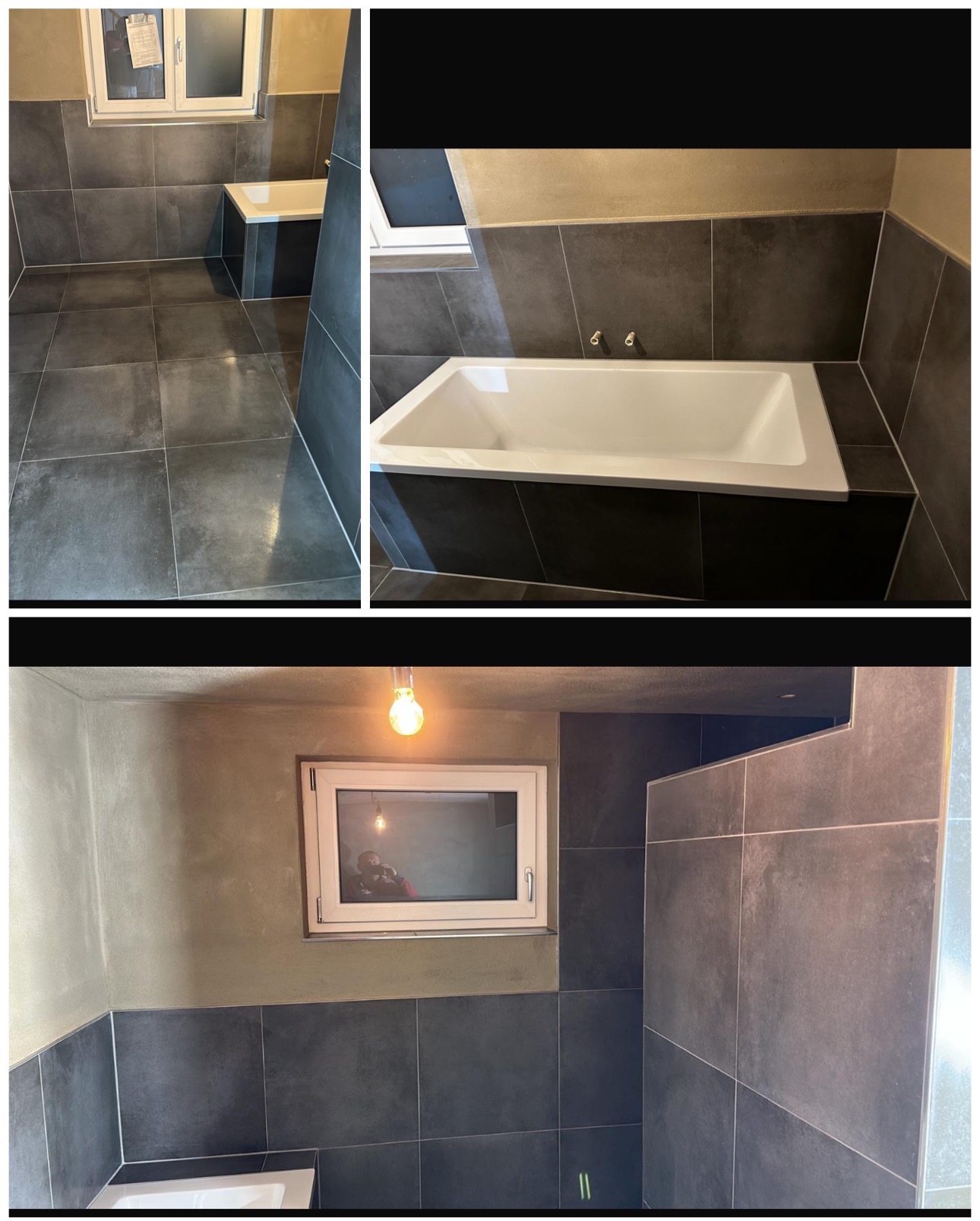 Wykończona łazienka z ciemnymi płytkami, białą wanną i oknem. Widoczne fugi i surowy beton na ścianach. Żarówka w oknie odbija sylwetkę osoby.