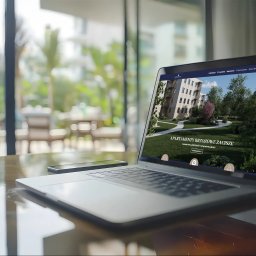 Vision Complex - Laptop prezentuje stronę internetową z wizualizacją osiedla 'Apartamenty Brzozowe Zacisze' na tle słonecznego balkonu. Obok leży smartfon.