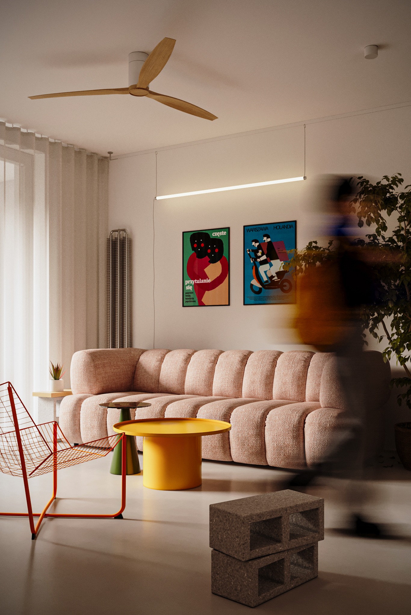 Nowoczesny salon z pudrowo-różową sofą, stolikami w odcieniach żółci i zieleni, oraz minimalistycznym oświetleniem. W tle plakaty i roślina doniczkowa.