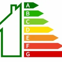 Ikona domu z kolorowymi strzałkami oznaczonymi A-G, symbolizującymi klasę energetyczną budynku, na białym tle. Grafika informacyjna.