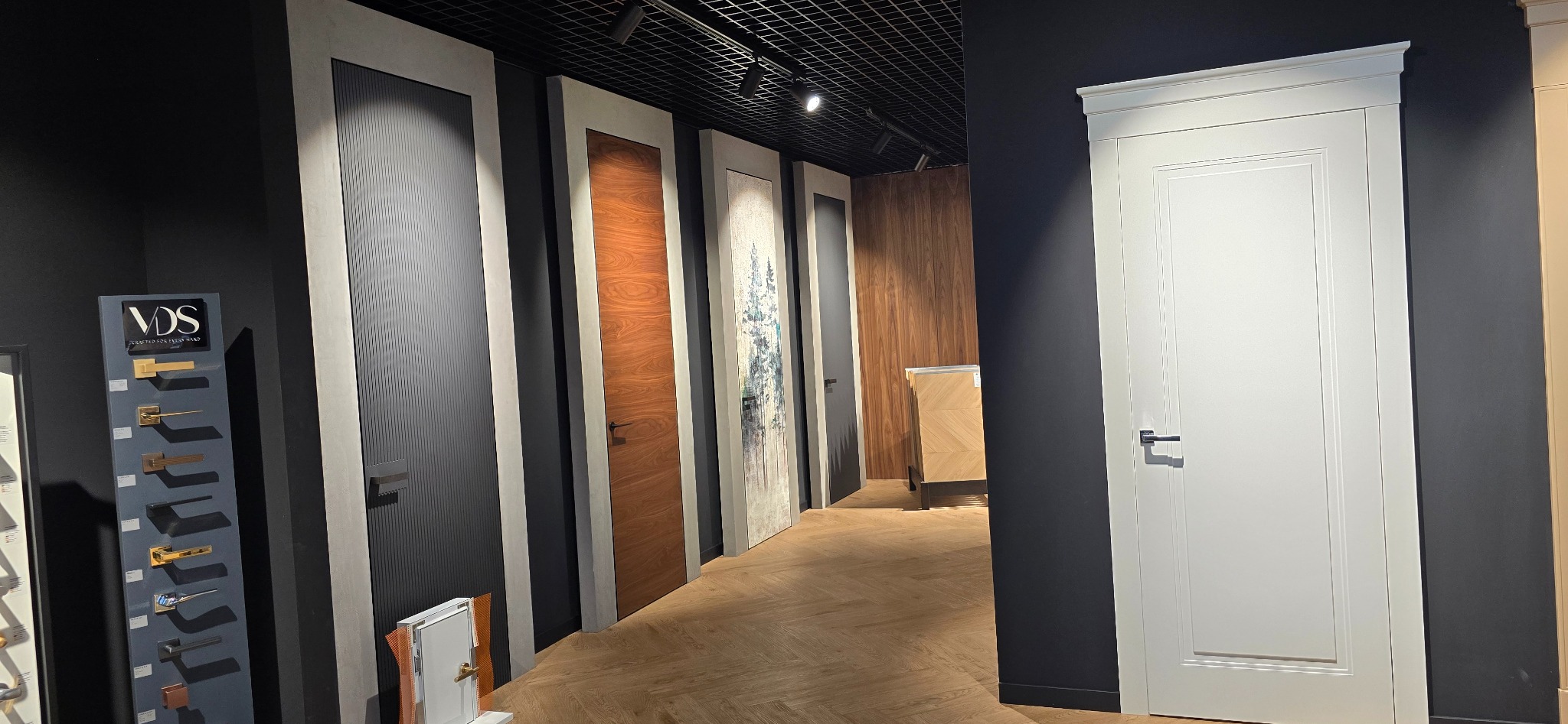 Ekspozycja różnorodnych drzwi wewnętrznych w salonie w Lublinie. Widoczne modele w różnych stylach, od nowoczesnych po klasyczne, z różnymi wykończeniami i kolorami.