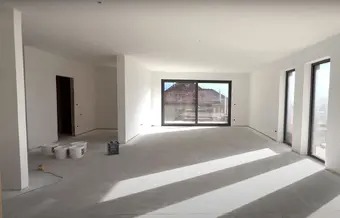 Jasne wnętrze po gładziowaniu ścian i sufitu. Widoczne duże okno przesuwne i dwa mniejsze okna. Podłoga przygotowana do dalszych prac wykończeniowych.