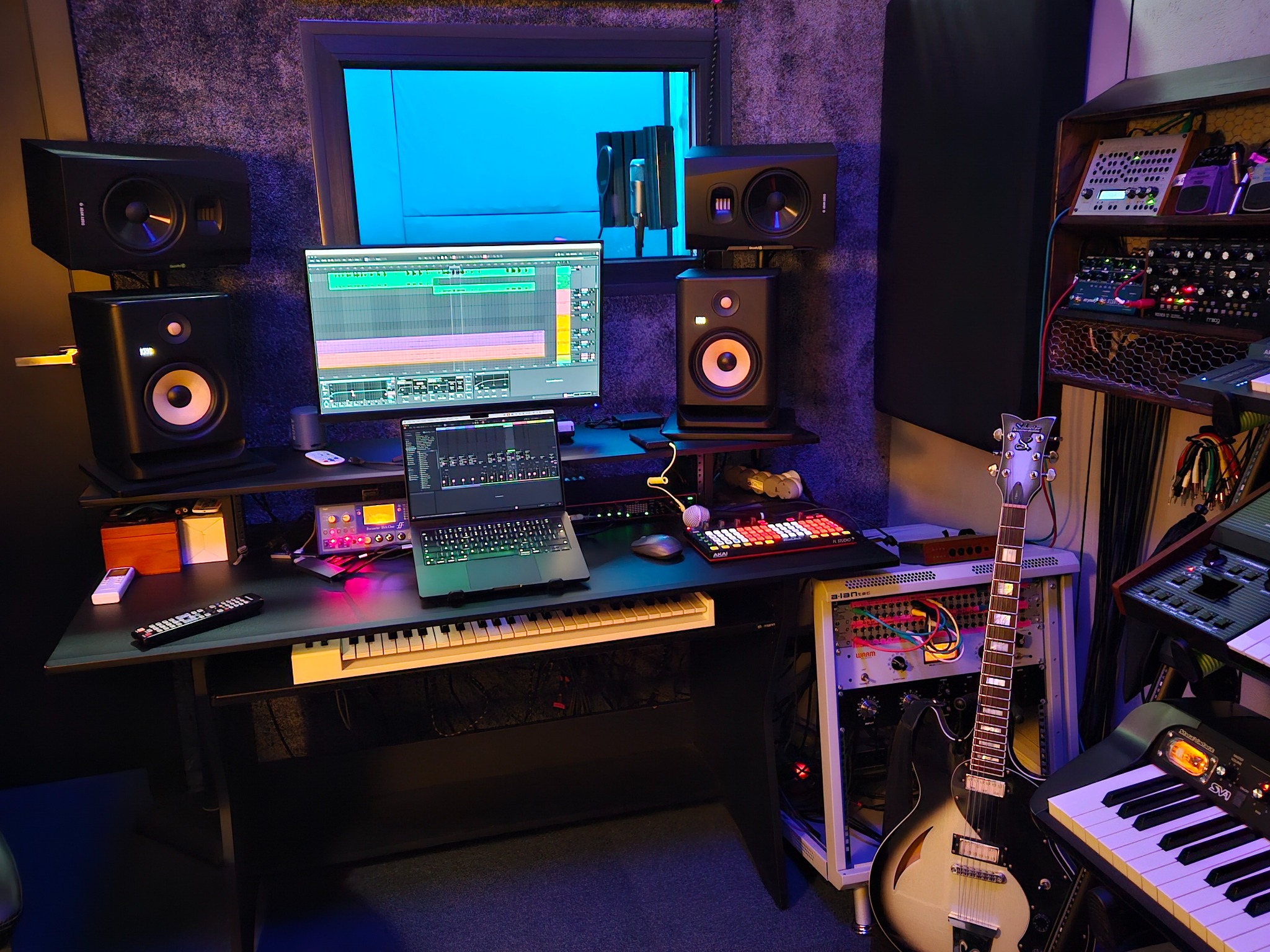 Profesjonalne studio nagrań: monitory studyjne, gitara elektryczna, klawiatura MIDI, kontrolery i ekran z oprogramowaniem DAW. Akustyka pomieszczenia zoptymalizowana.