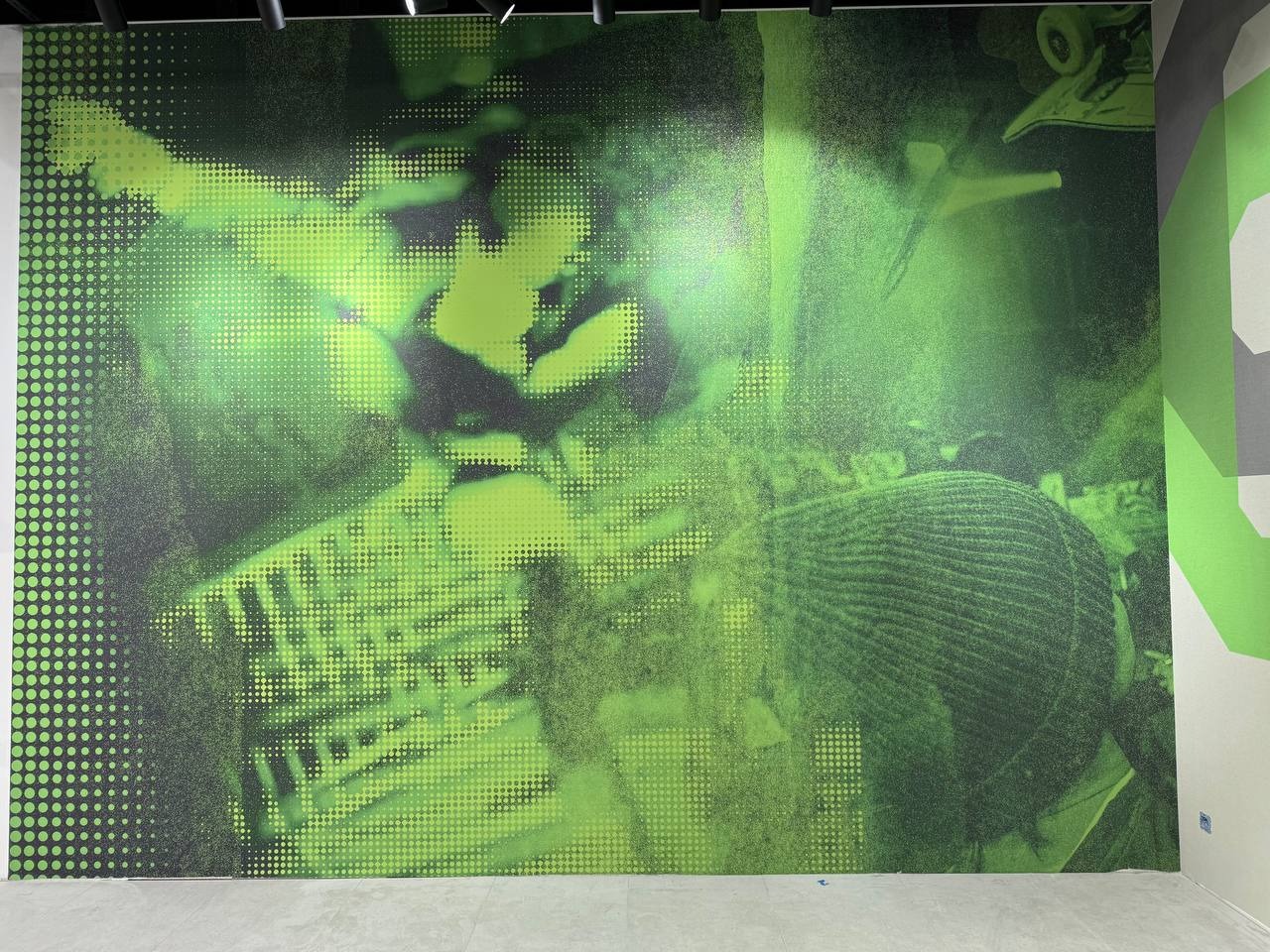 Zielona fototapeta z motywem graffiti na ścianie, widok z dołu. Nowoczesne wykończenie wnętrza. Efektowna dekoracja ścienna w stylu miejskim.