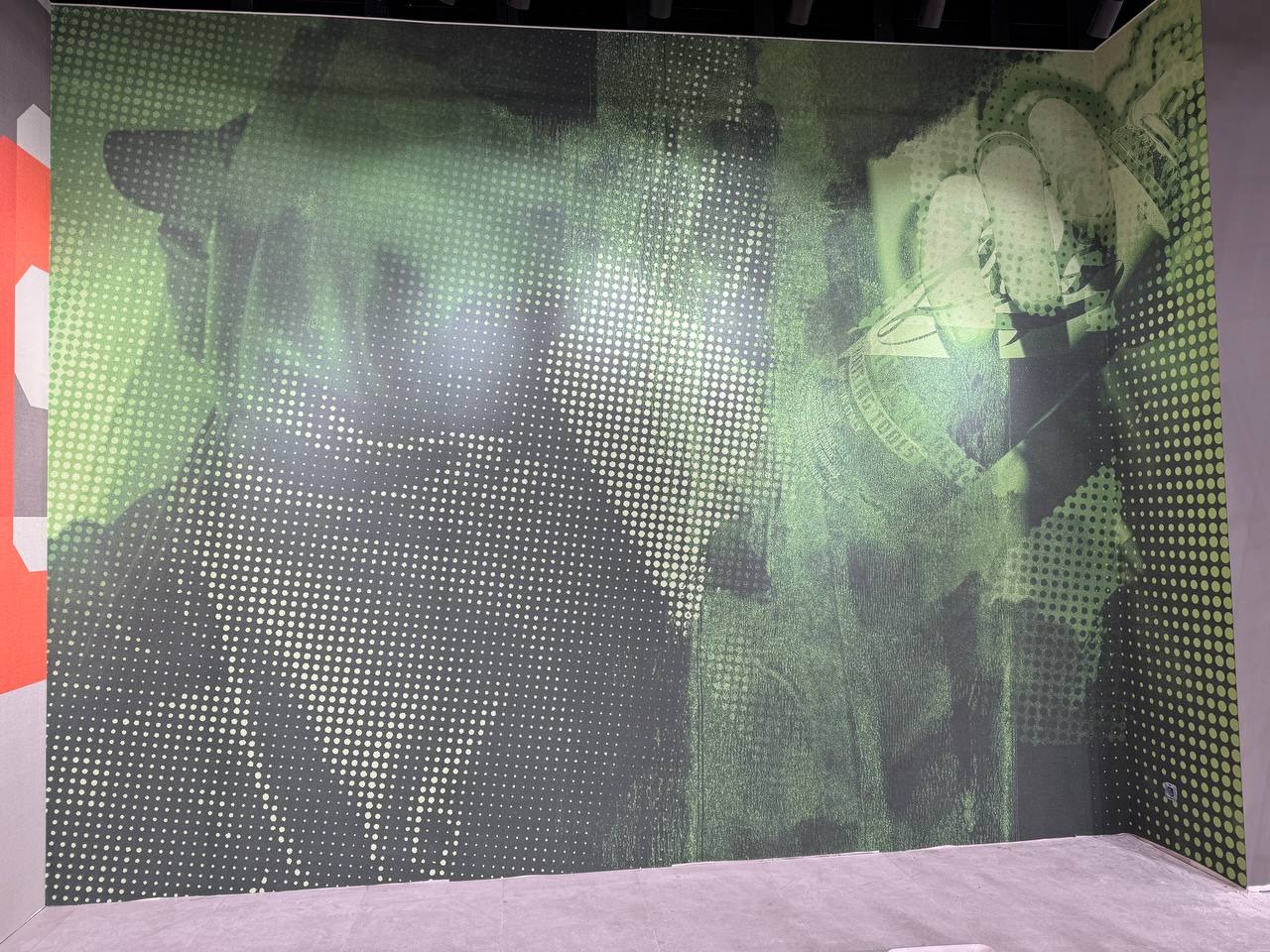 Pokój z fototapetą w odcieniach zieleni, z motywem banknotów dolarowych i deseniem w kropki, tworzącym efekt retro. Wykończone ściany i podłoga.