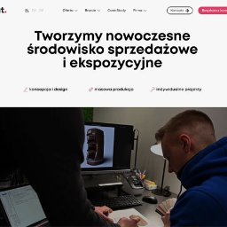Artiworks Wiesław Małolepszy - Zespół projektowy pracuje nad wizualizacją 3D ekspozytora na monitorze. Widoczne szkice i laptop. Jasne biuro, nowoczesny design. Koncepcja i design w praktyce.
