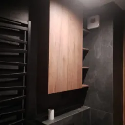 Nowoczesna łazienka z drewnianą szafką wiszącą, czarnym grzejnikiem drabinkowym i płytkami imitującymi marmur. Minimalistyczny design z akcentem na naturalne materiały.