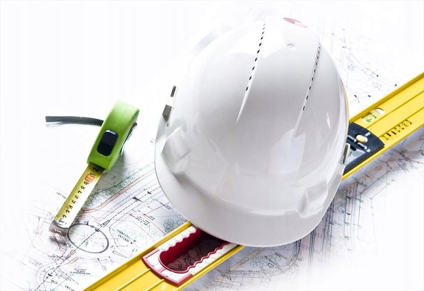 Biały kask budowlany, poziomica i zwinięta miarka na planach architektonicznych. Narzędzia pracy inżyniera na jasnym tle, detale projektu.