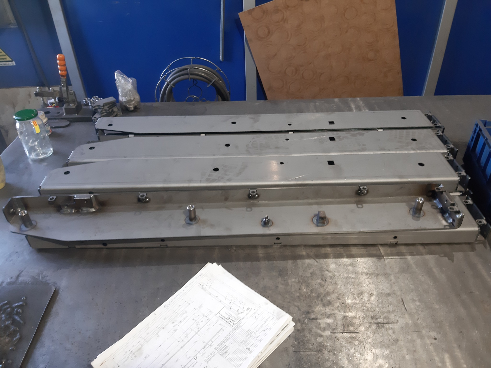 Metalowe elementy konstrukcyjne z otworami i spawami na stole warsztatowym w Wierzchowie, gotowe do dalszej obróbki lub montażu.