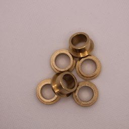 Minitech Adam Palma - Sześć mosiężnych tulejek o różnych kształtach, ułożonych na jasnym tle. Widoczne detale obróbki i połysk metalu.