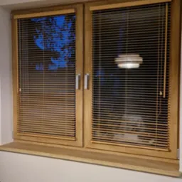 Dwa okna z drewnianymi żaluzjami aluminiowymi, widok na zewnątrz i lampę. Naturalne światło podkreśla strukturę drewna. Detal wnętrza z bliska.
