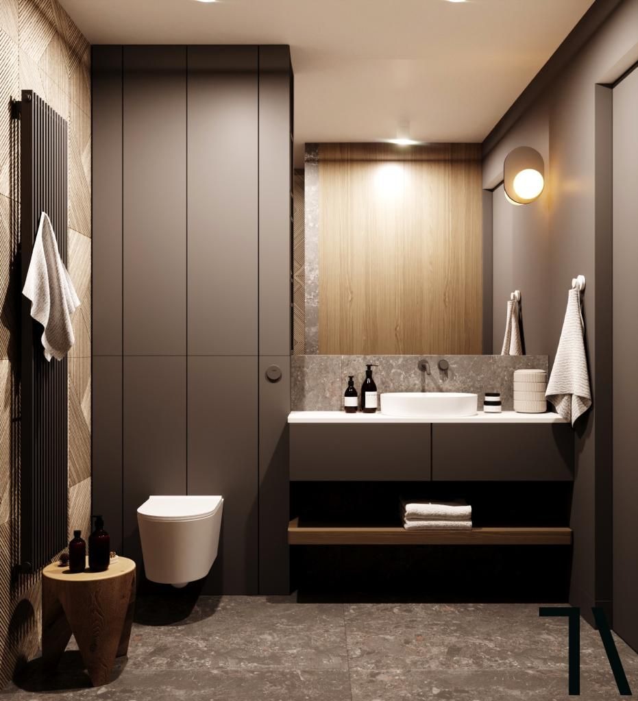 Stylowa, nowoczesna łazienka z szarą zabudową, drewnianymi akcentami i okrągłą umywalką. Minimalistyczny design z wiszącą toaletą i dekoracyjnym grzejnikiem.