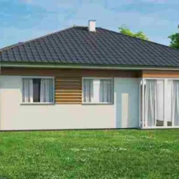 Nowoczesny, parterowy dom z dwuspadowym dachem krytym ciemną dachówką, z jasną elewacją częściowo wykończoną drewnianą okładziną, otoczony zielonym trawnikiem i drzewami.