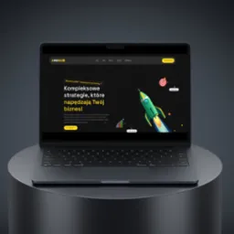 Laptop prezentuje stronę internetową z grafiką rakiety i hasłem o kompleksowych strategiach marketingowych. Widoczny tekst: Marketing 360° i skalowanie sprzedaży.