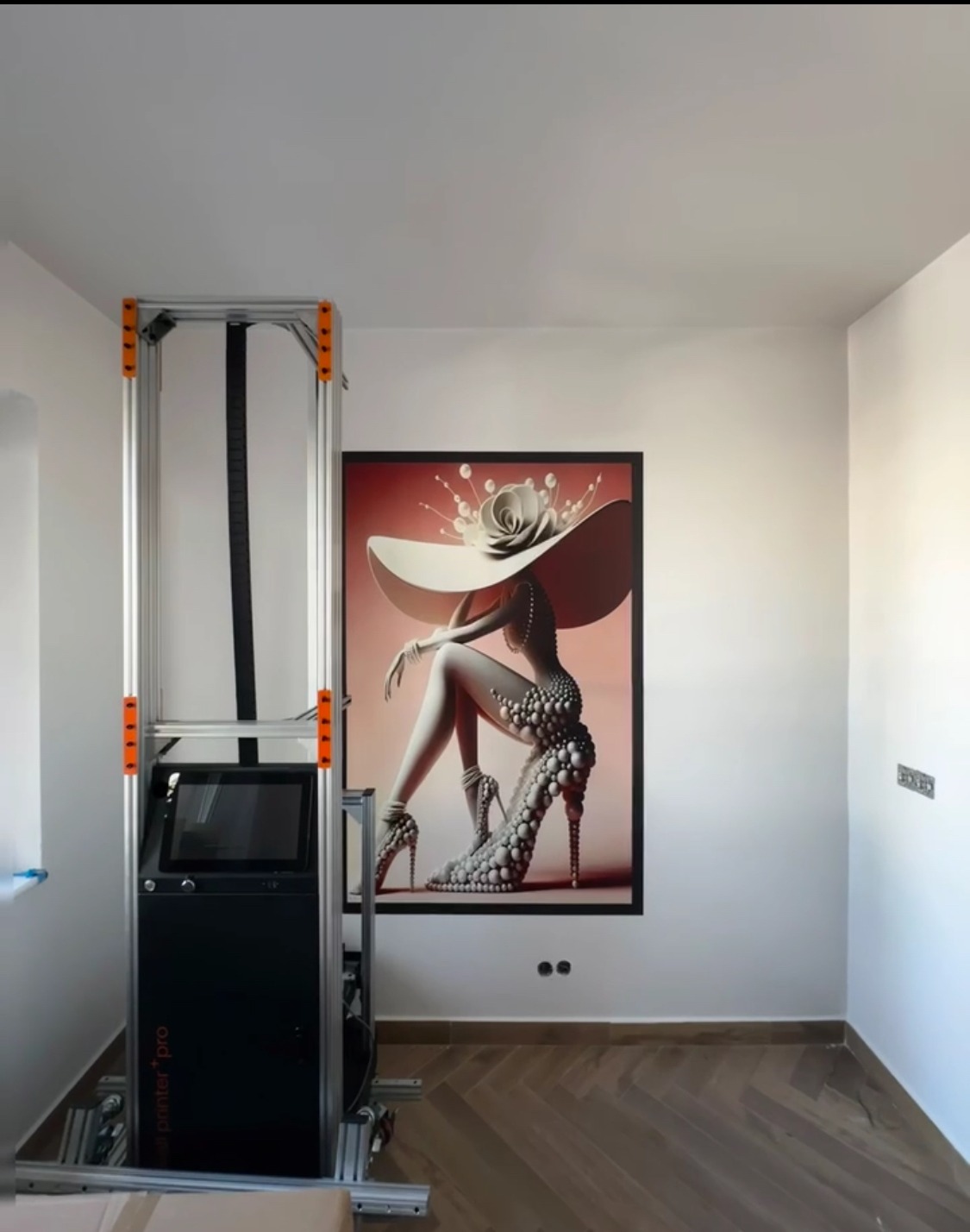 Drukarka pionowa maluje na ścianie obraz kobiety w kapeluszu. Parkiet na podłodze. Nowoczesne wykończenie wnętrza. Druk UV na ścianie.