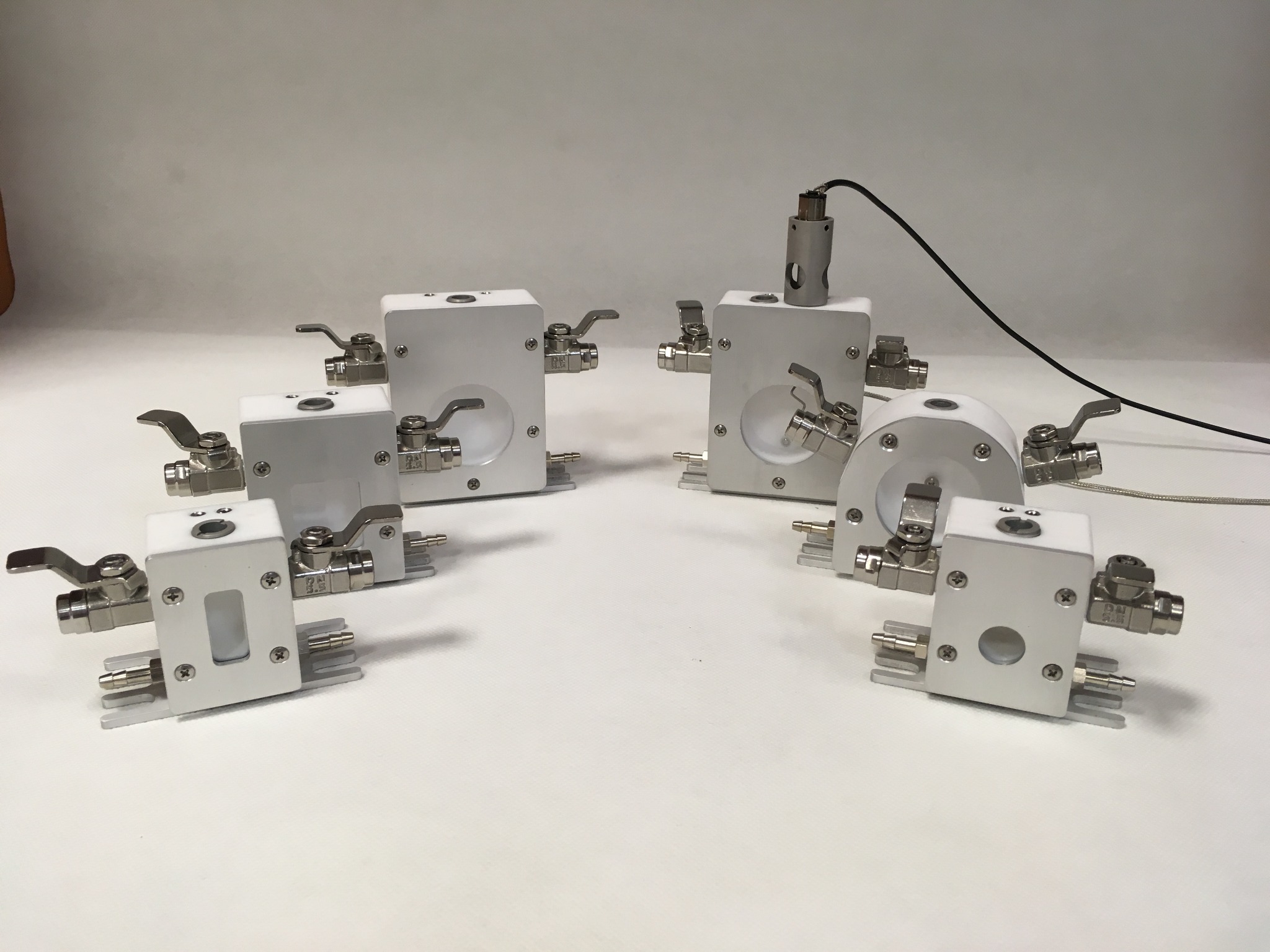 Precyzyjnie wykonane, białe moduły z zaworami i przyłączami, ustawione na białym tle. Widoczne detale obróbki CNC i montażu, prezentujące wysoką jakość wykonania.