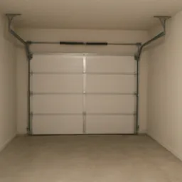 Wykończony garaż z jasnymi ścianami o delikatnej fakturze i betonową posadzką. Widoczna brama garażowa segmentowa, biała, z poziomymi przetłoczeniami.