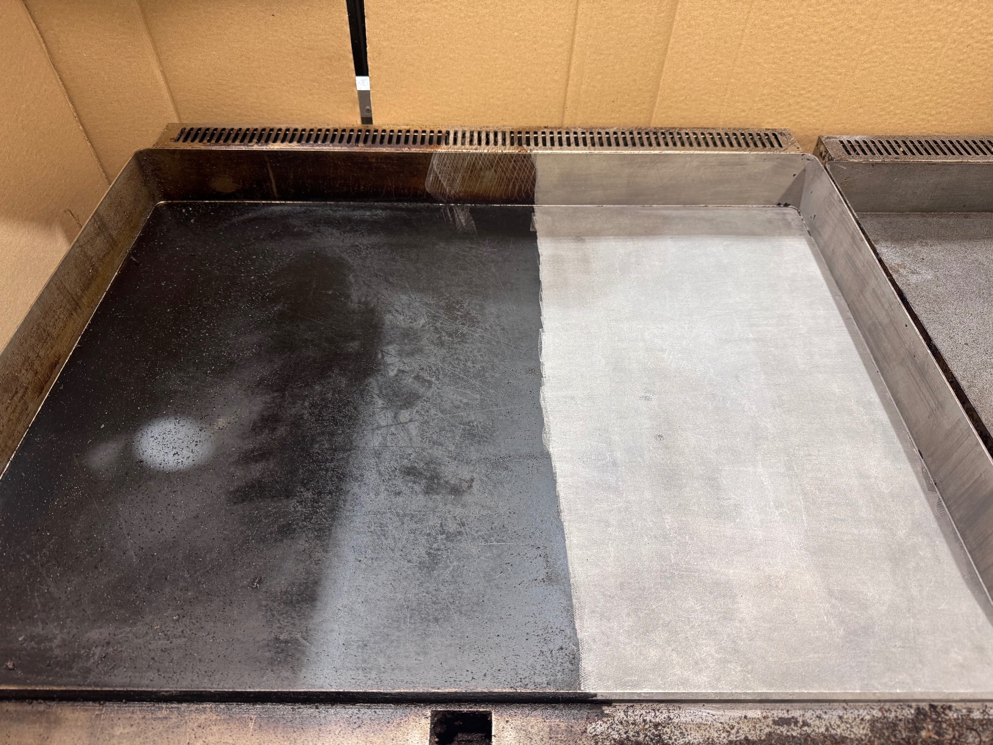 Czyszczenie przemysłowe: Połowa metalowej powierzchni przed i po czyszczeniu, widoczna wyraźna różnica w zabrudzeniu i połysku. Efekt czyszczenia.