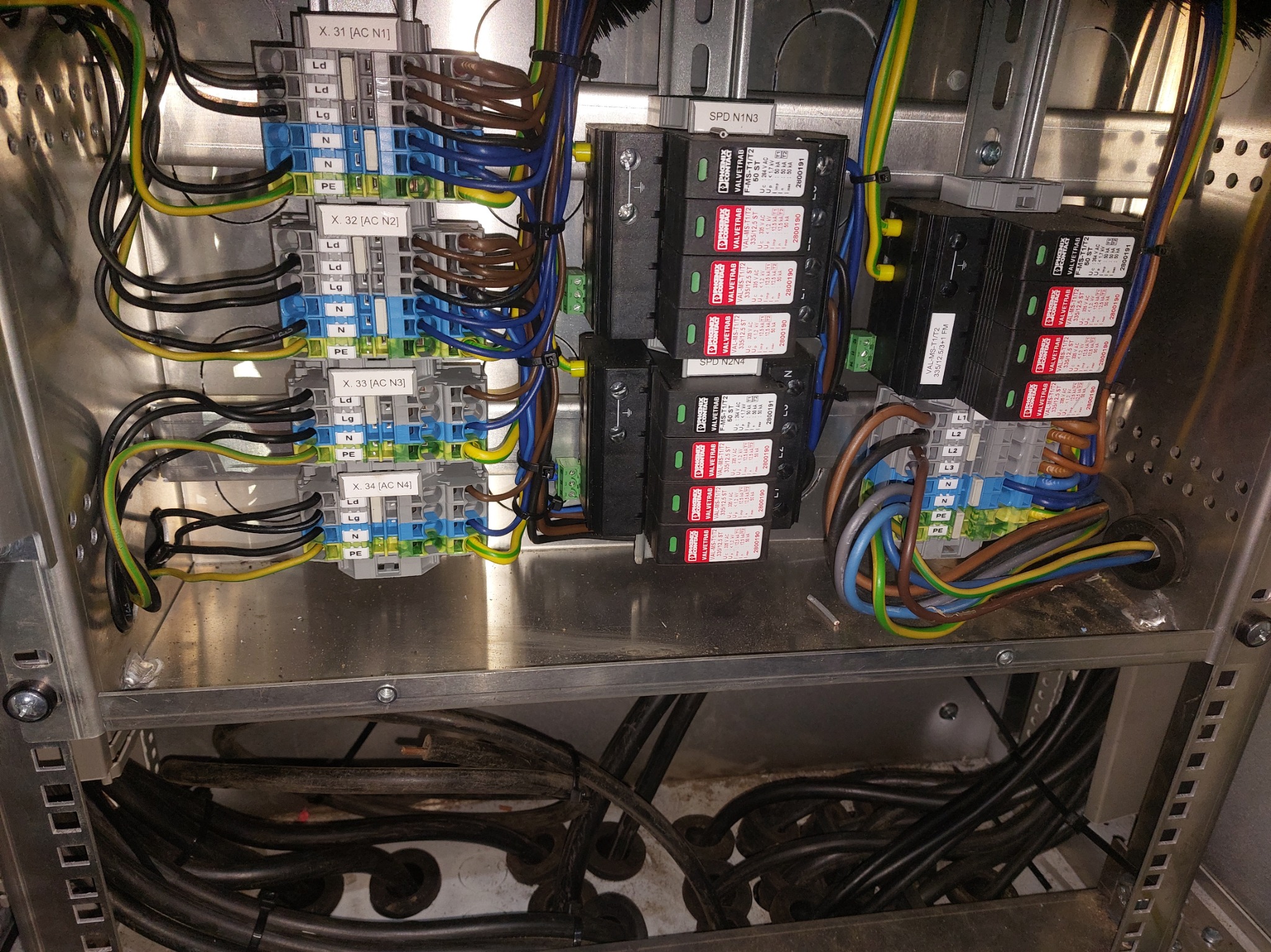 Rozdzielnica elektryczna z zabezpieczeniami przepięciowymi w Rybniku. Widoczne kable, listwy zaciskowe i moduły VALVETRAB. Precyzyjny montaż w metalowej obudowie.