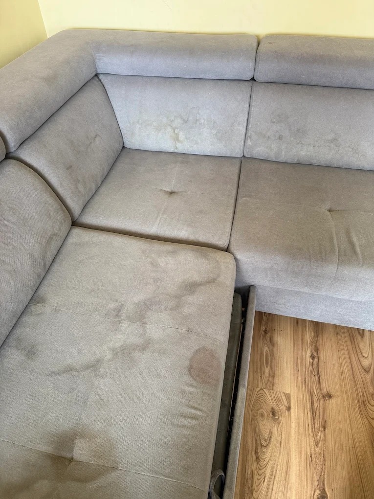 Przed: Zabrudzona tapicerka narożnika przed czyszczeniem – widoczne plamy, przebarwienia i ślady użytkowania.