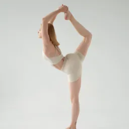 Kobieta w beżowym stroju sportowym prezentuje zaawansowaną pozycję taneczną na białym tle, z tatuażem na kostce i delikatnym oświetleniem.