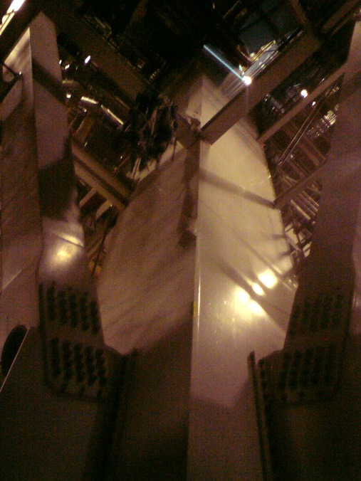 Nietypowe ujęcie z dołu na konstrukcję dachu z elementami blacharskimi i oświetleniem, ukazujące skomplikowaną strukturę i detale wykończenia.