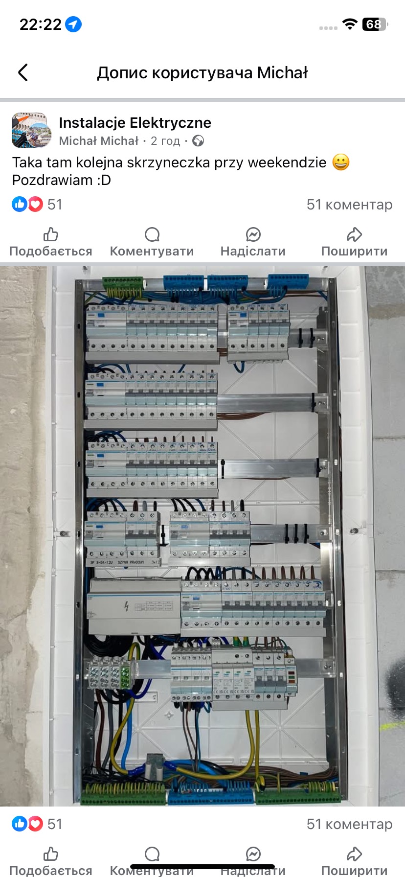 Rozdzielnica elektryczna z licznymi bezpiecznikami i okablowaniem wewnątrz białej obudowy, zamontowana na surowej ścianie w trakcie prac wykończeniowych.