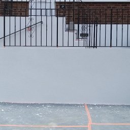 Paxon LTD - Świeżo otynkowana, jasnoszara elewacja frontowa domu z numerem 19, widoczna z poziomu gruntu, z elementami dekoracyjnymi i czarną, kutą balustradą.