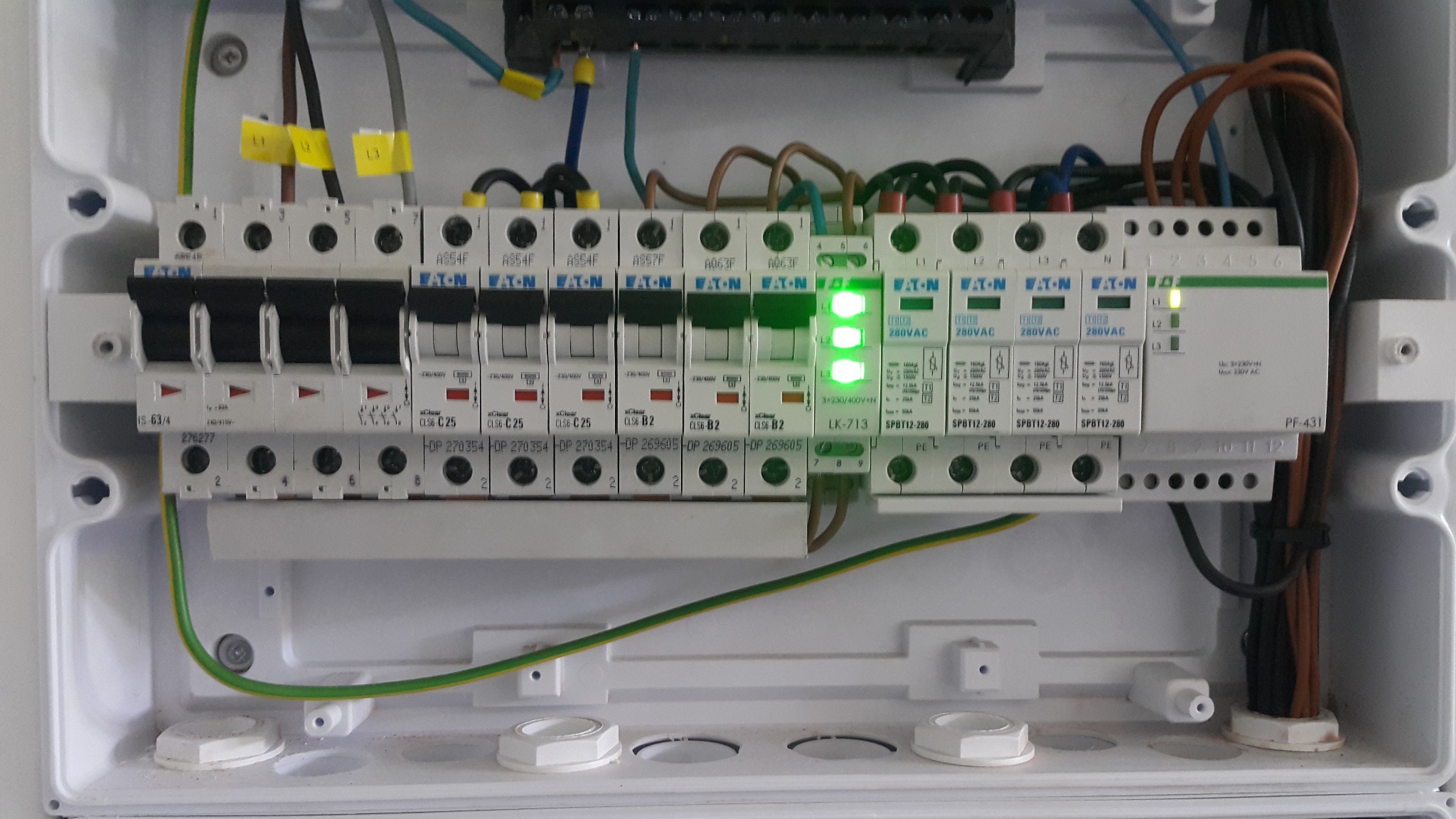 Rozdzielnica elektryczna po montażu w Chorzowie. Widoczne bezpieczniki, przewody i listwa zasilająca. Zielone diody sygnalizują poprawne działanie.