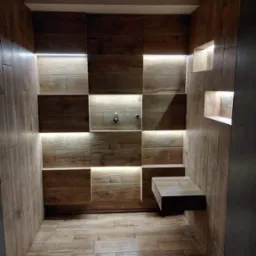 Nowoczesna kabina prysznicowa z drewnopodobnymi płytkami, podświetleniem LED i półką wnękową. Minimalistyczny design, ciepłe oświetlenie, teksturalne wykończenie.