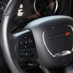 Skórzana kierownica Dodge z przyciskami sterowania i logiem, widoczny kokpit. Detailing wnętrza auta w Częstochowie.