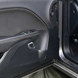 Mobilny Urban Shine Detailing - Wnętrze samochodu z otwartymi drzwiami, widoczny panel drzwiowy z elementami sterującymi szybami, lusterko boczne i fragment karoserii, zabezpieczone folią ochronną.