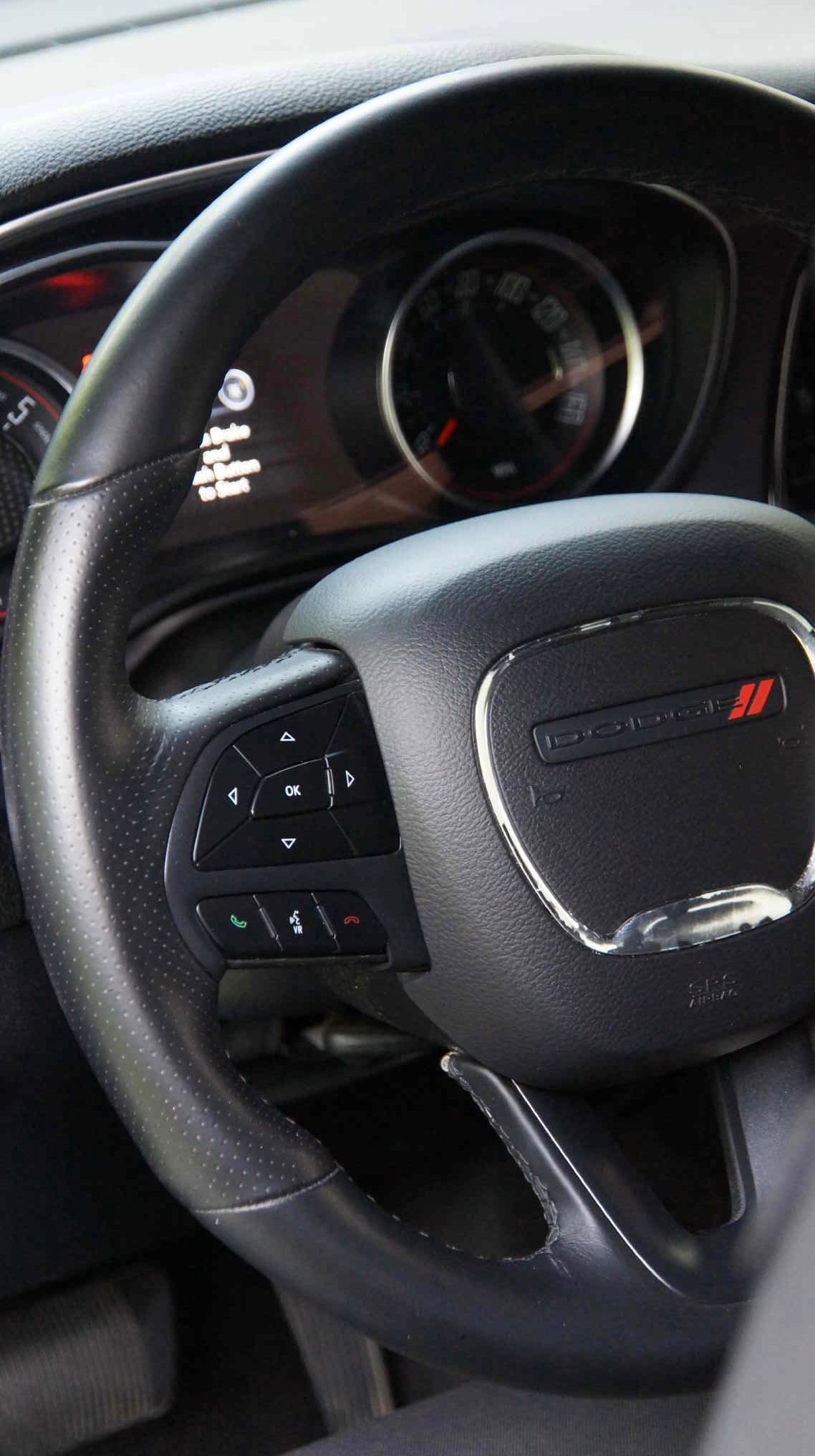 Skórzana kierownica Dodge z przyciskami sterowania i logiem, widoczny kokpit. Detailing wnętrza auta w Częstochowie.