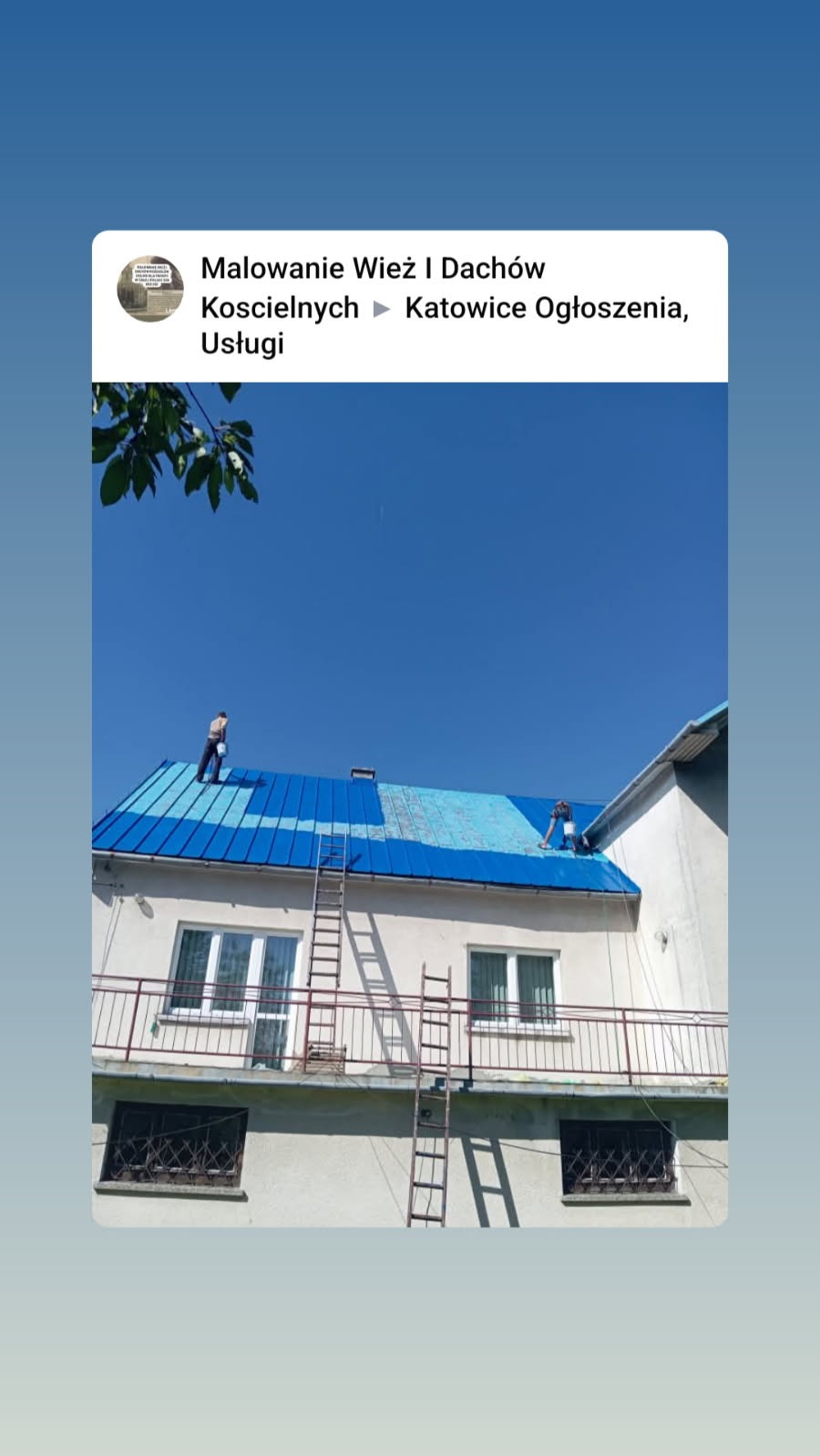 Etap malowania dachu budynku z użyciem drabiny. Widoczni pracownicy podczas pracy. Częściowo pomalowany dach na niebiesko, błękitne niebo w tle.