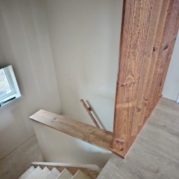 GM Vector plus - Wnętrze z drewnianymi schodami w trakcie montażu, widok z góry. Elementy konstrukcyjne z surowego drewna. Realizacja w Sieradzu.