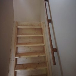 GM Vector plus - Jasne, drewniane schody strychowe z poręczą, widziane z dołu. Proste wykończenie, naturalne drewno, oświetlenie z góry. Minimalistyczny design.