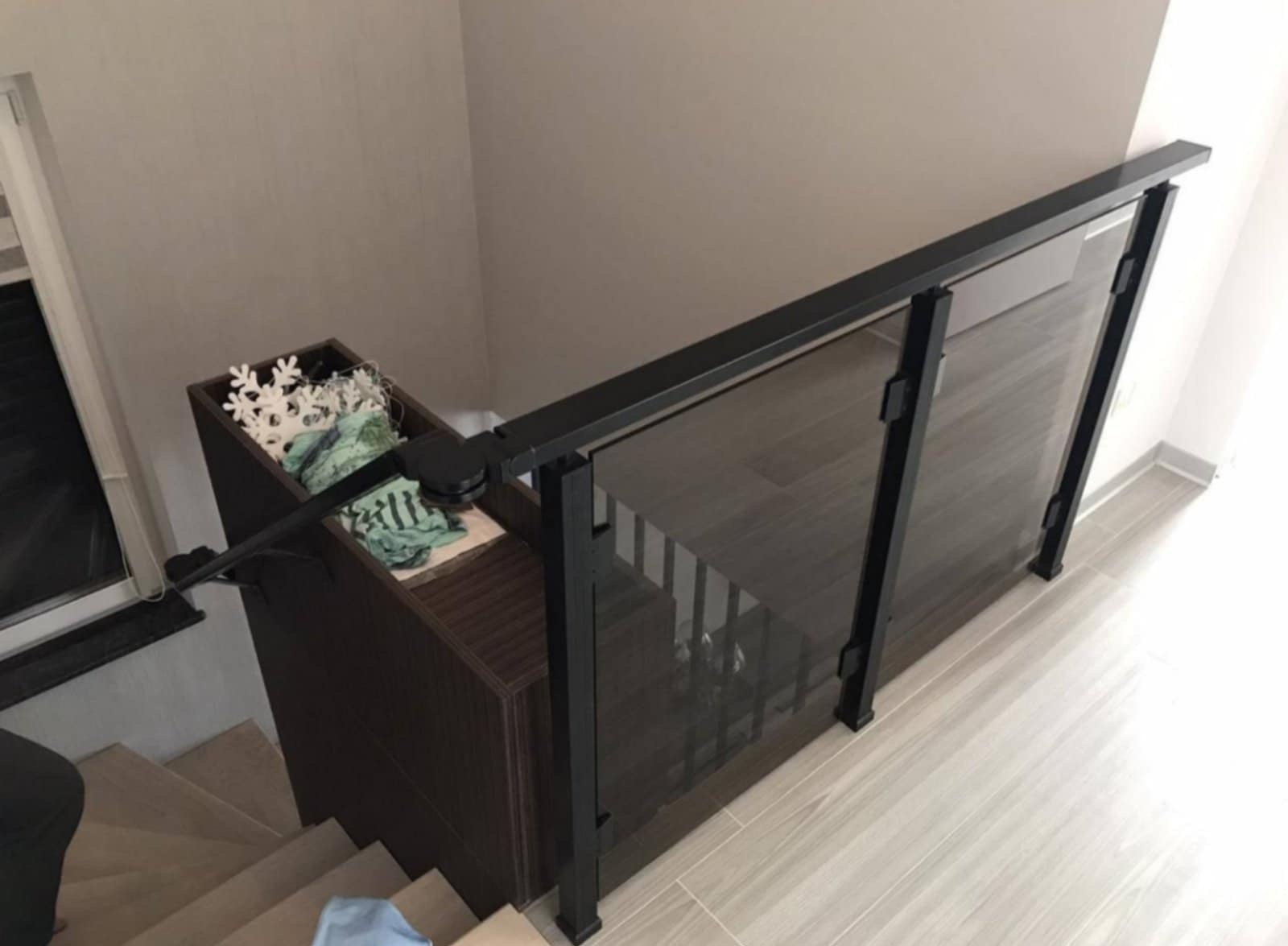 Nowoczesna szklana balustrada schodowa z czarnymi elementami w domu w Warszawie. Widok z góry, jasne wnętrze, minimalistyczny design.