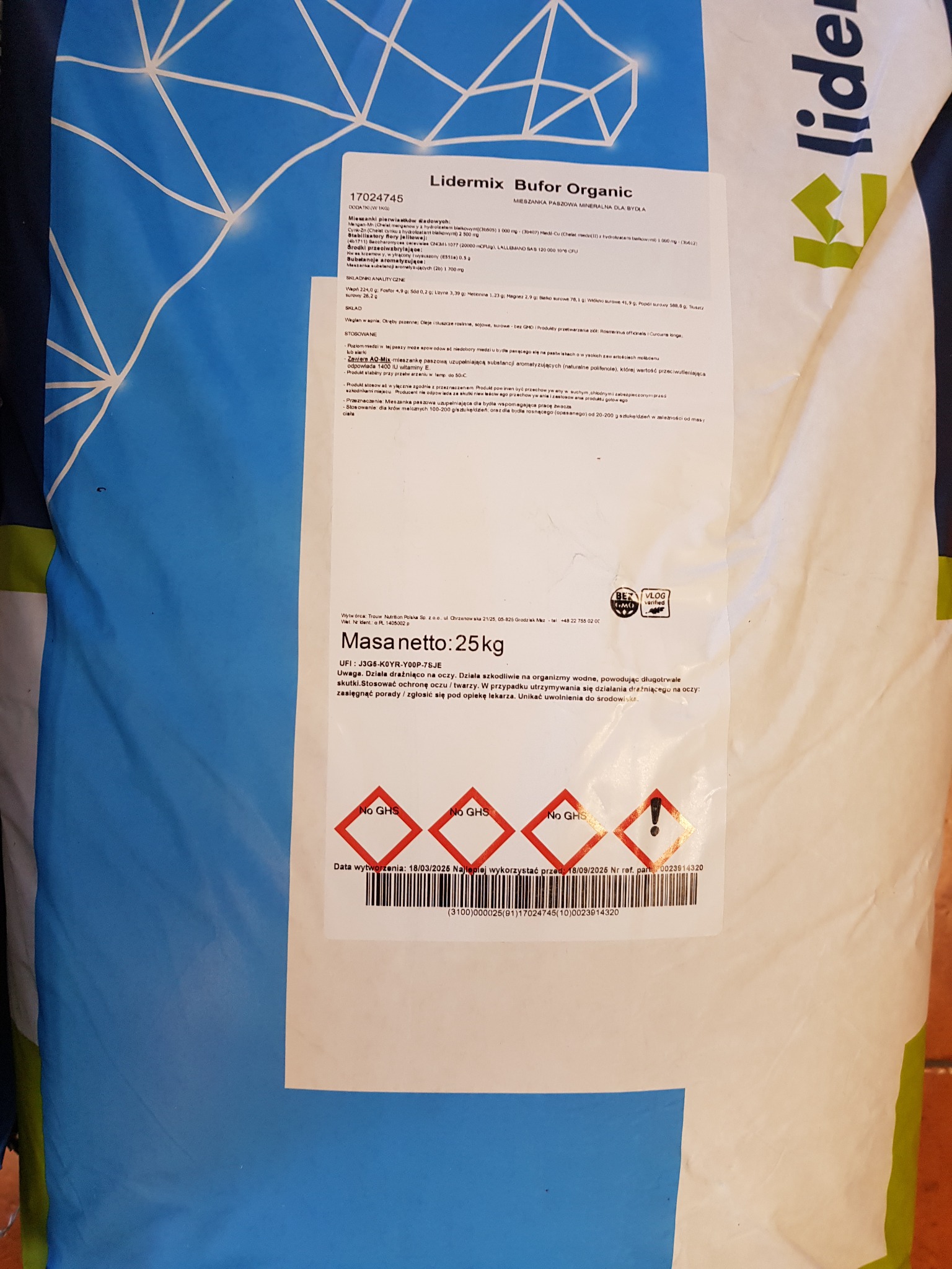 Worek paszowy z napisem Lidermix Bufor Organic, 25kg. Etykieta z datą ważności 18/09/2026 i informacjami o składzie. Widoczne znaki ostrzegawcze.